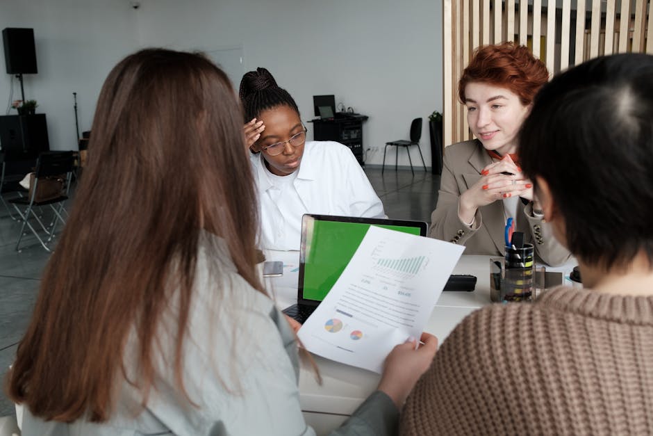 A diverse group of adults engaged in a business meeting in a modern office setting.